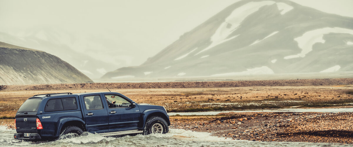 Landmannalaugar, Iceland - July 2, 2018: 4WD vehicle car travel off road in landscape of Landmannalaugar in highland of Iceland, Nordic, Europe. The place is famous for summer outdoor trekking way.